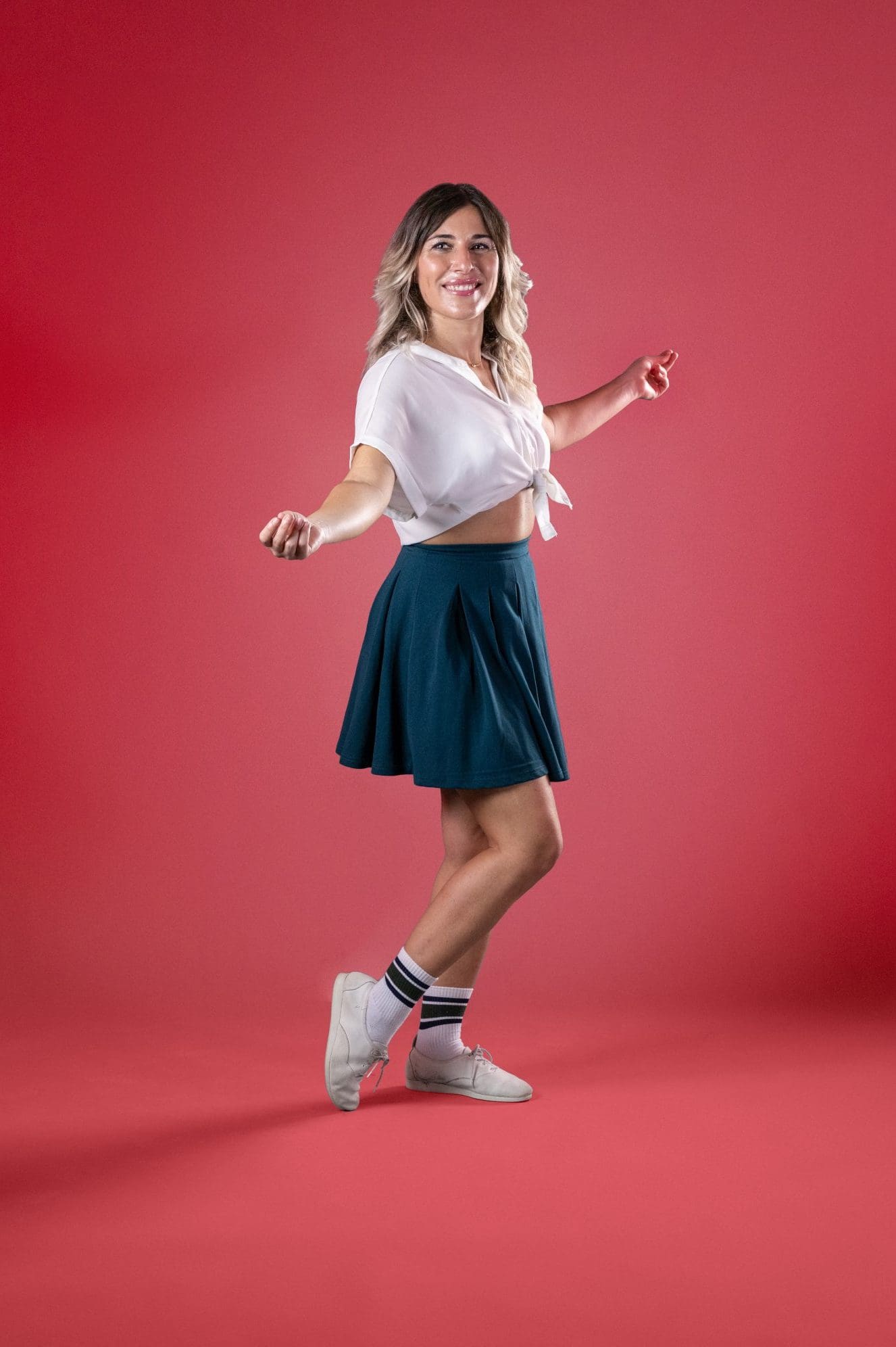 Alessandra D'Errico, insegnante di Swing, specializzata in Boogie Woogie e Lindy Hop, posa su sfondo rosso in stile vintage.